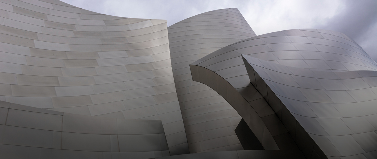 A modern, abstract architectural structure with curved metallic surfaces.